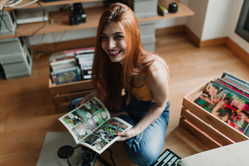 A beautiful young woman smile at camera while she read a comic book