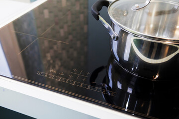 Close-up of stainless steel pots on an induction cooker in a modern kitchen. the concept of a...