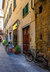 Obraz na płótnie Canvas View of narrow street with tables of old trattoria in Florence, Tuscany, Italy. Architecture and landmark of Florence. Cityscape of Florence