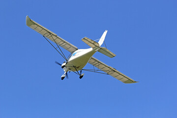 Ultralight airplane flying in a blue sky	