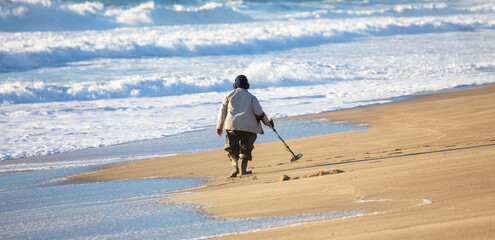 Man with metal detector on the beach