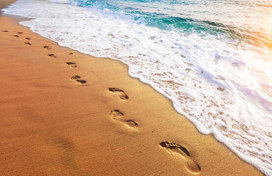 footprints on  tropical beach and beautiful  wave