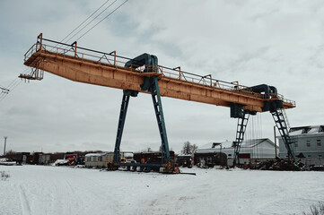 Abandoned gantry crane in the snow in winter, landfill