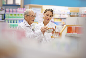 Providing clients with all the facts. Shot of a young pharmacist helping an elderly customer.