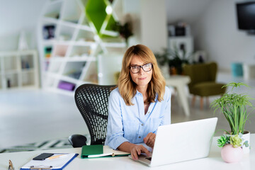 Businesswoman working on her laptop while sitting at the office