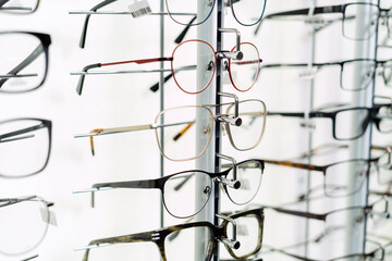 Row of glasses at an opticians, eyeglasses shop. Stand with glasses in the store of optics.