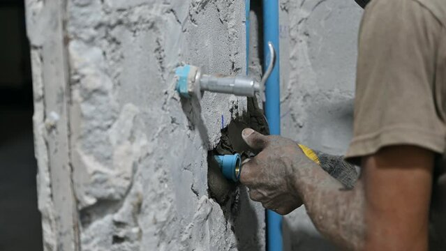 Plasterer plastering on brick wall in bathroom