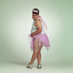 Sexy legs. An overweight man comically dressed-up in a pink fairy costume showing his leg off.