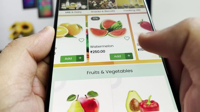 Man ordering food online using smartphone. Ordering fruits from an online grocery store. 