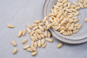Gray bowl of peeled or blanched whole almonds on a granite background. Shallow depth of field
