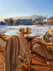 Zimowy ogród z widokiem na gór, gorąca kawa pod kocykiem w mroźne dni