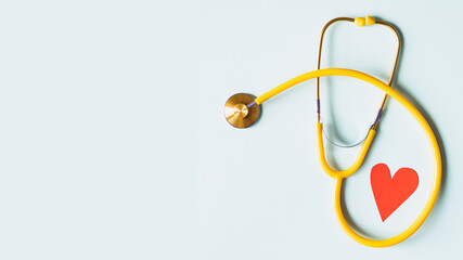 yellow stethoscope and heart shape background in the corner
