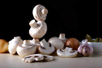 Close-up background of whole and sliced champignons with other cooking ingredients. Selective focus.