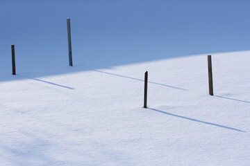 Wooden sticks along the borders of the beds under the snow