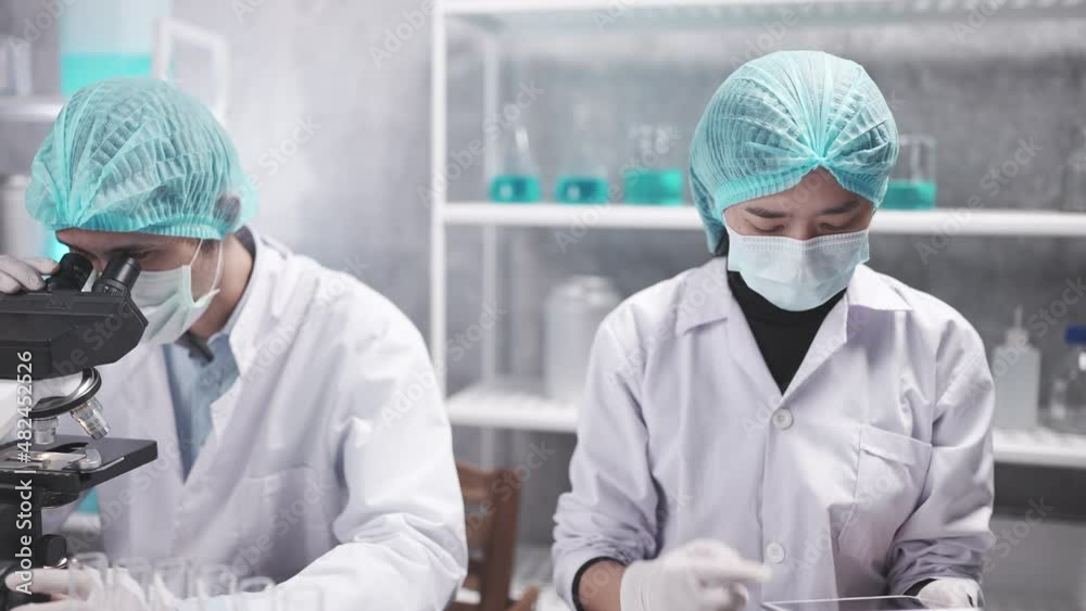 Wall mural medical scientist team are working on science laboratory research term by using microscope and scien