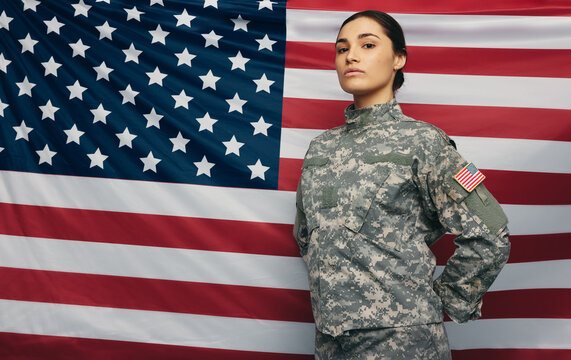 Courageous soldier standing against the United States flag - Powered by Adobe