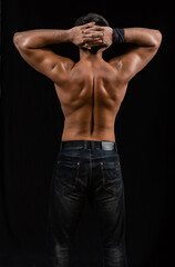 Fototapeta na wymiar muscular man. athlete posing in a black T-shirt and jeans. studio portrait