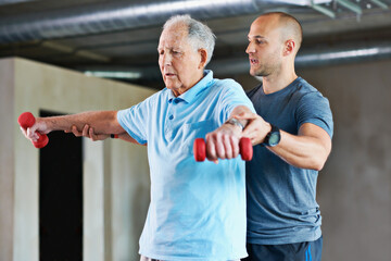 It's going to get easier. Shot of a physiotherapist helping a senior man with weights.