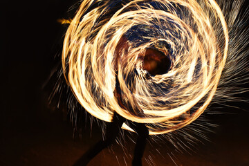 Vibrant fire light performance  shaped like a circle and spiral, in dark background