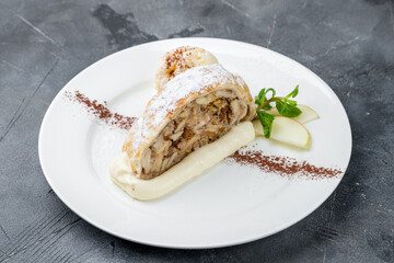 Apple strudel with ice cream on grey table