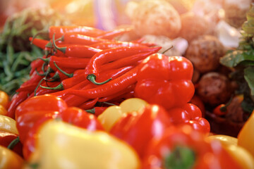 Red and yellow sweet paprika peppers on bazaar counter in Egypt with sunlight. Farm products concept