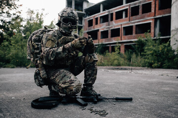 Soldier man scattering bullets from a rifle on the ground, reloading a rifle
