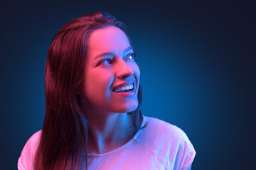 Neon close up portrait of young woman in white dress on dark blue background