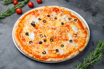 Pizza with seafood on plate on grey table