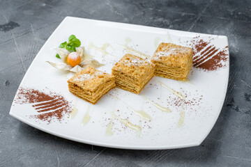 a piece of honey cake on plate on grey table