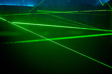Fototapeta na wymiar Bright green neon laser lights illuminate the darkness creating lines and triangle shapes in sci-fi effect.