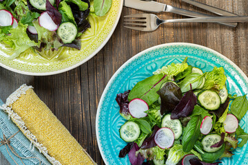 Two bowls of salat,fork and knife.Tasty and healthy food. Flat lay. Rustic food photography..