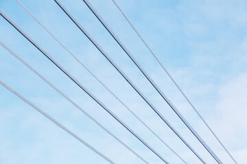 Fototapeta premium Wires covered with frost and snow against a blue sky. Snow sticking to wires.