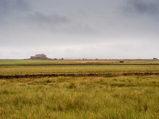 Fototapeta premium View of Lindisfarne Castle accross the fields at Holy Island, Noprthumberland, UK