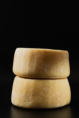 whole italian parmesan or pecorino cheese on a dark background. packaging advertising