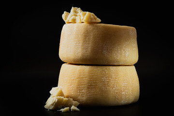 whole italian parmesan or pecorino cheese on a dark background. packaging advertising