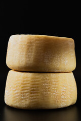 whole italian parmesan or pecorino cheese on a dark background. packaging advertising