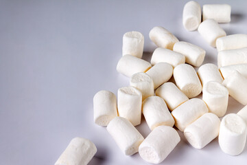 Fototapeta na wymiar white marshmallow scattered over white background, close-up, selective focus