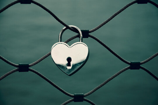 Heart shaped love lock attached to bridge in Paris. Valentine's day retro background