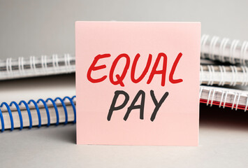 Notepad with text Equal Pay with black marker on white background