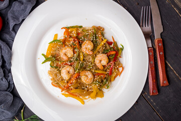 fried Rice noodles with shrimp and vegetables funchosa on dark table top view
