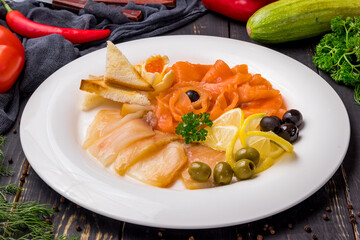 different fish slicing on a plate on dark table