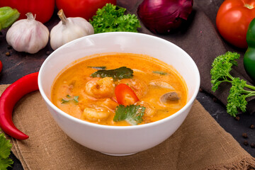 Tom Yam soup with shrimps on white bowl on dark table