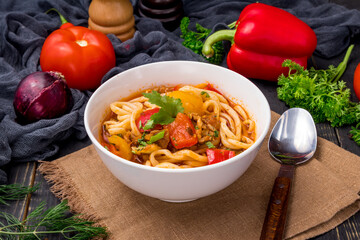 Lagman asian soup with meat, vegetables and noodles, dark table, uzbek cuisine