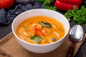 Tom Yam soup with shrimps on white bowl on dark table