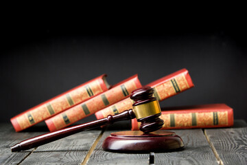 Legal Law and Justice concept - Open law book with a wooden judges gavel on table in a courtroom or...