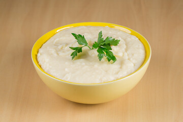 mashed potatoes in yellow bowl on wooden background