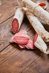 Factory for the production of meat products, boiled-smoked and dried sausages. Traditional spicy sausage, ready to eat, lies sliced on a wooden table. The concept of handmade meat products.