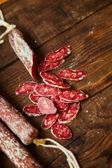 Factory for the production of meat products, boiled and smoked sausages. Traditional spicy sausage, ready to eat, lies sliced on a wooden table. The concept of handmade meat products. 