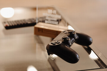 video game controller on glass table. gaming, technology and entertainment concept - blue gamepad controller on table