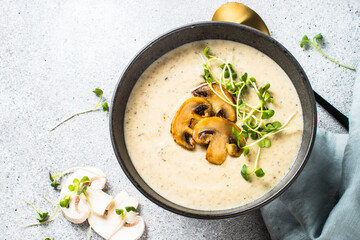 Mushroom Cream Soup on light stone table. Top view with copy space.